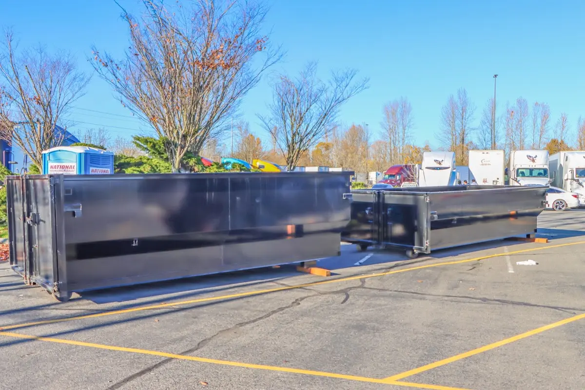 Professional dumpster rental service with roll-off container on residential driveway in College Place